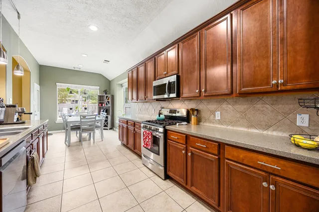 a kitchen with stainless steel appliances granite countertop wooden cabinets a stove top oven a sink and dishwasher