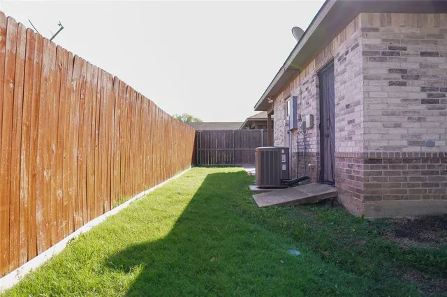 a view of a backyard with a small cabin and wooden fence