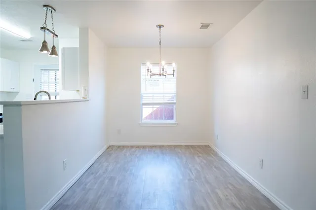 a view of a kitchen with wooden floor and a window