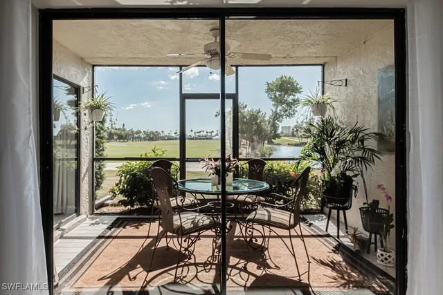 a view of a balcony dining table and chairs with swimming pool in the backyard