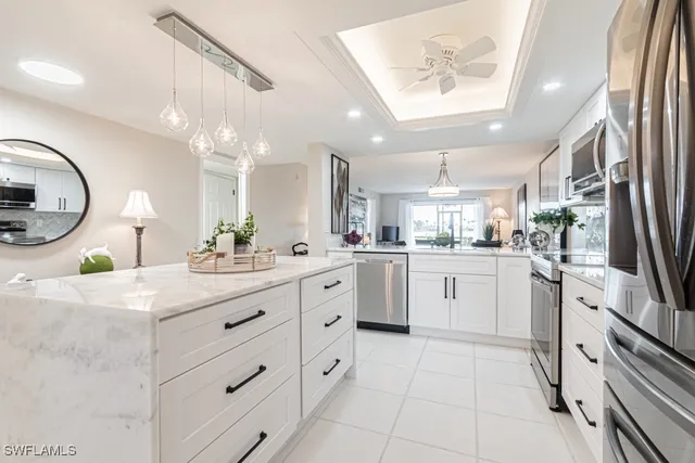 a kitchen with a white cabinets and chandelier