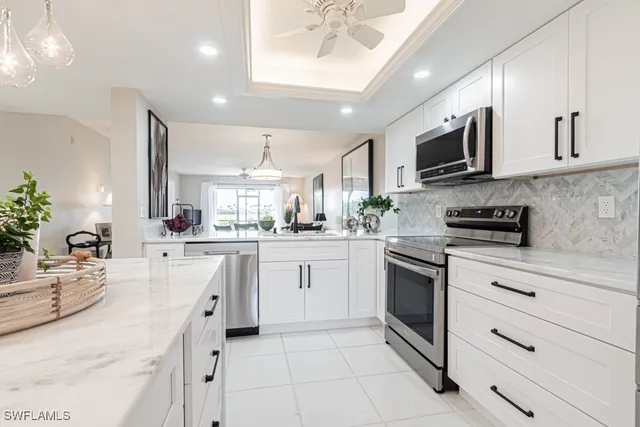 a kitchen with stainless steel appliances white cabinets and a refrigerator