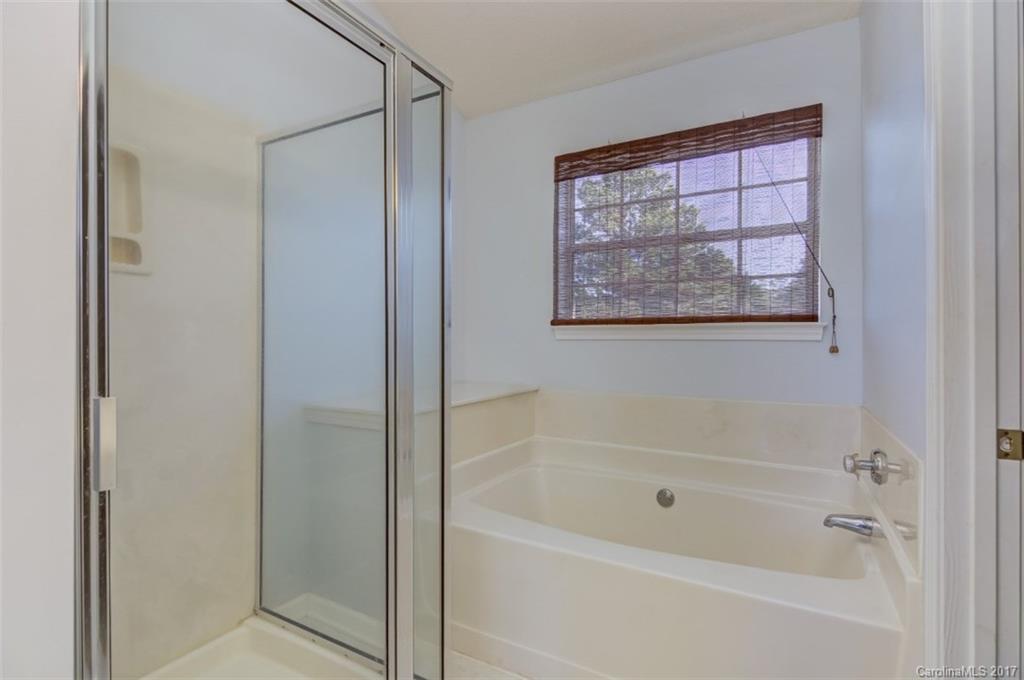 12206 Marathon Hill Road Charlotte, NC 28269 - Photo 18 of 23 a white bath tub sitting next to a shower