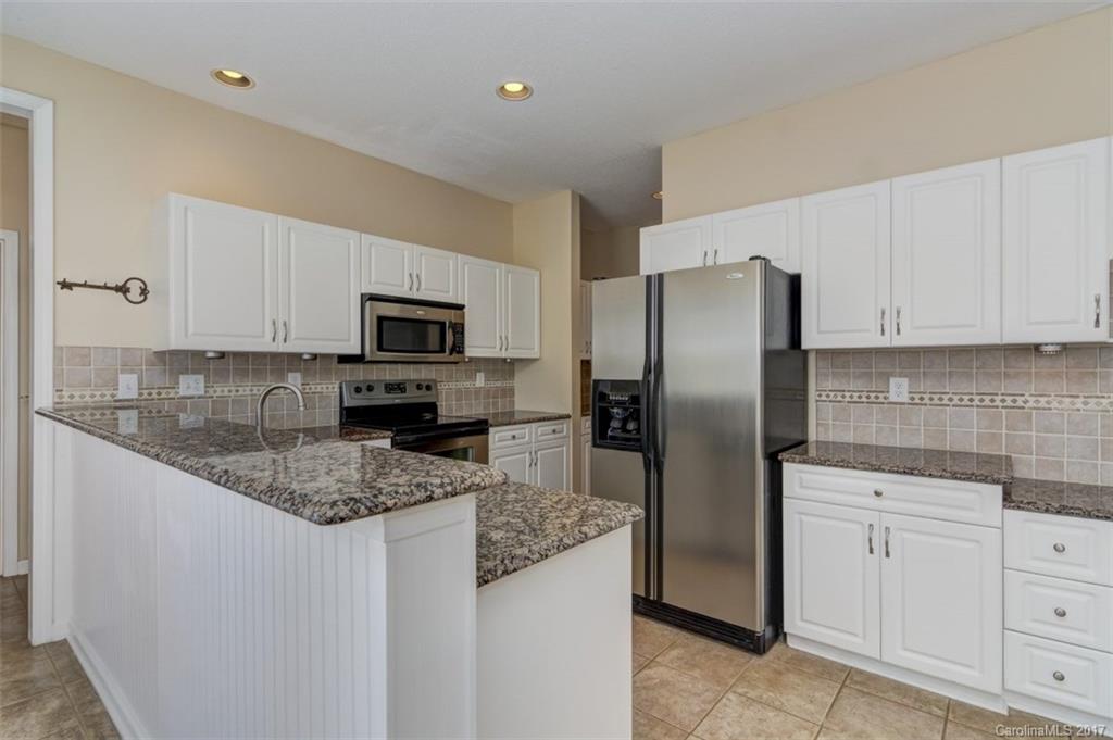 12206 Marathon Hill Road Charlotte, NC 28269 - Photo 3 of 23 a kitchen with stainless steel appliances granite countertop white cabinets a refrigerator and a stove