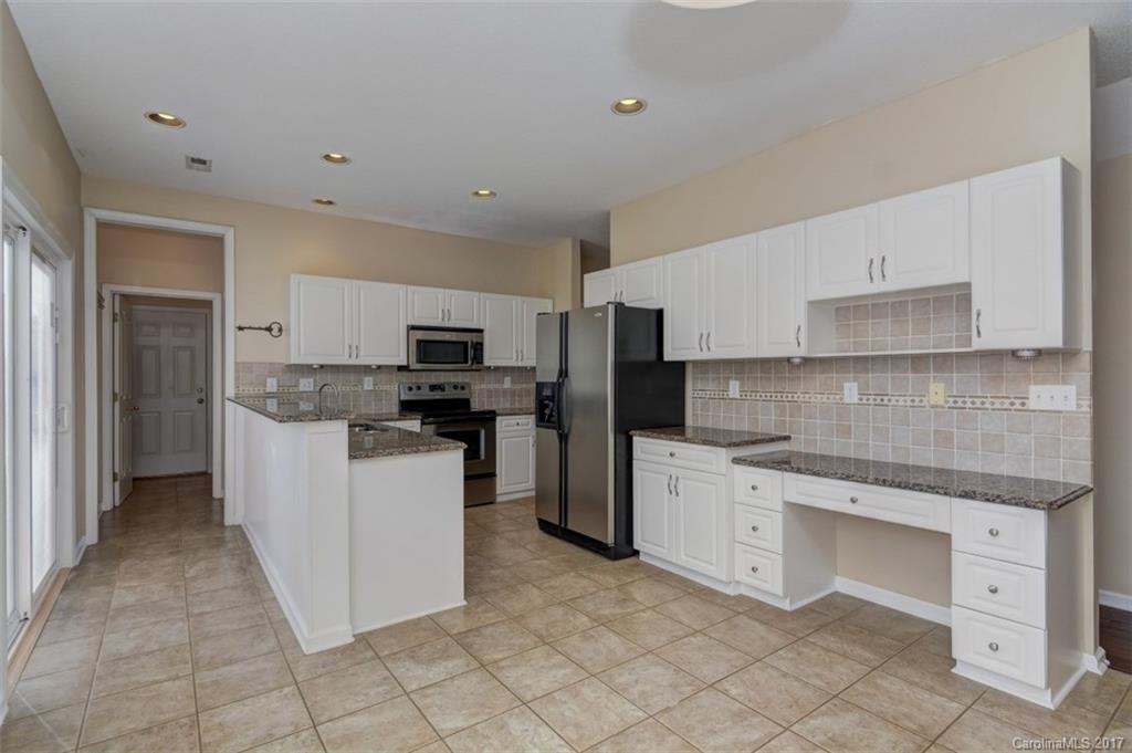 12206 Marathon Hill Road Charlotte, NC 28269 - Photo 4 of 23 a kitchen with white cabinets stainless steel appliances and sink