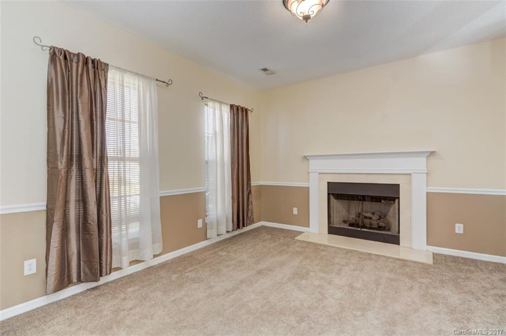 12206 Marathon Hill Road Charlotte, NC 28269 - Photo 8 of 23 a view of an empty room with a fireplace and a window