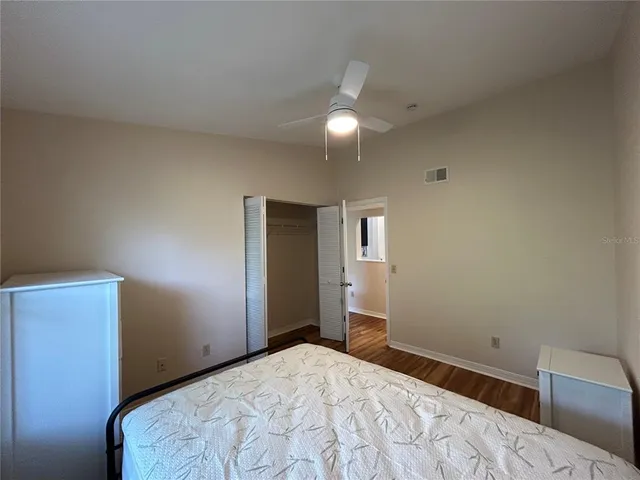 a bedroom with a bed and a lamp on dresser