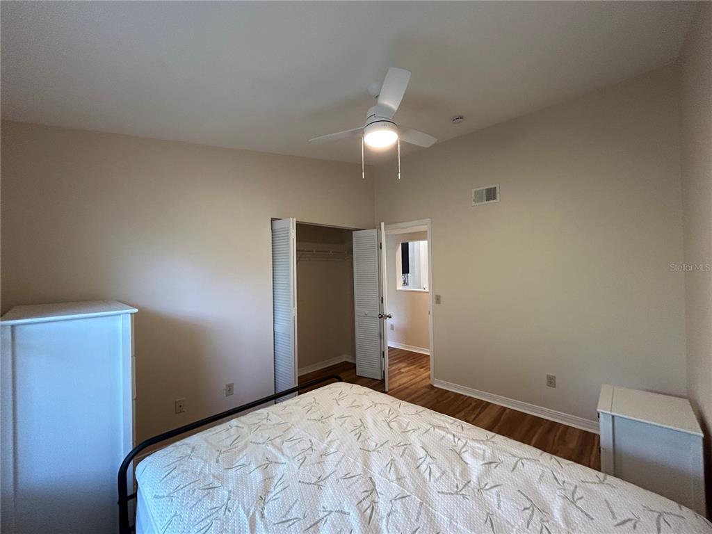 2360 Southwest Archer Road, Unit 1012 Gainesville, FL 32608 - Photo 11 of 28 a bedroom with a bed and a lamp on dresser