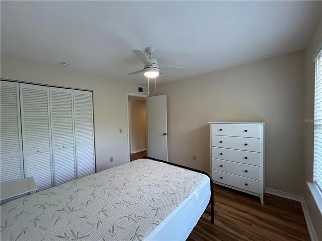 a bedroom with a bed and a ceiling fan