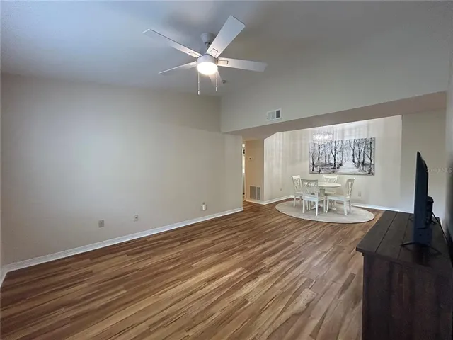 a view of a room with wooden floor fan and window