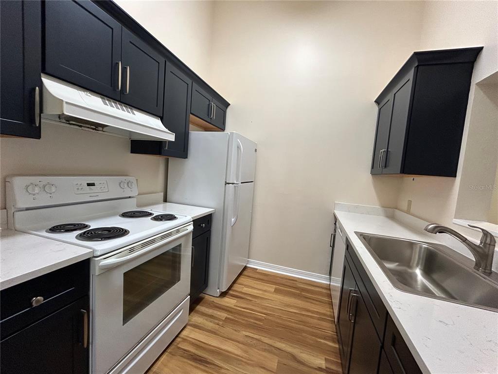 2360 Southwest Archer Road, Unit 1012 Gainesville, FL 32608 - Photo 6 of 28 a kitchen with a stove and a microwave