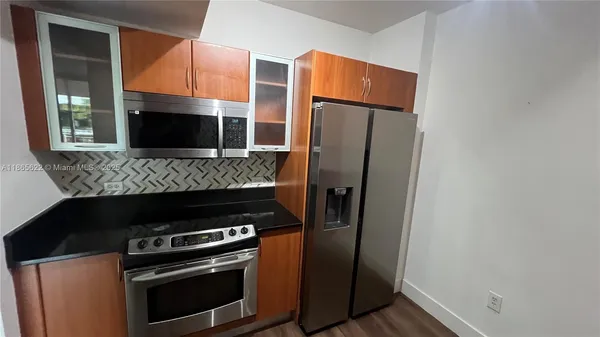 a kitchen with stainless steel appliances and wooden cabinets