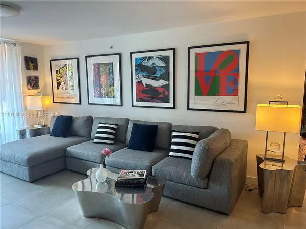 a living room with furniture a flat screen tv and a large window