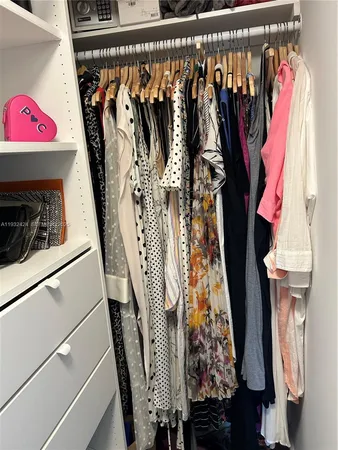 a view of walk in closet with clothes and shoes