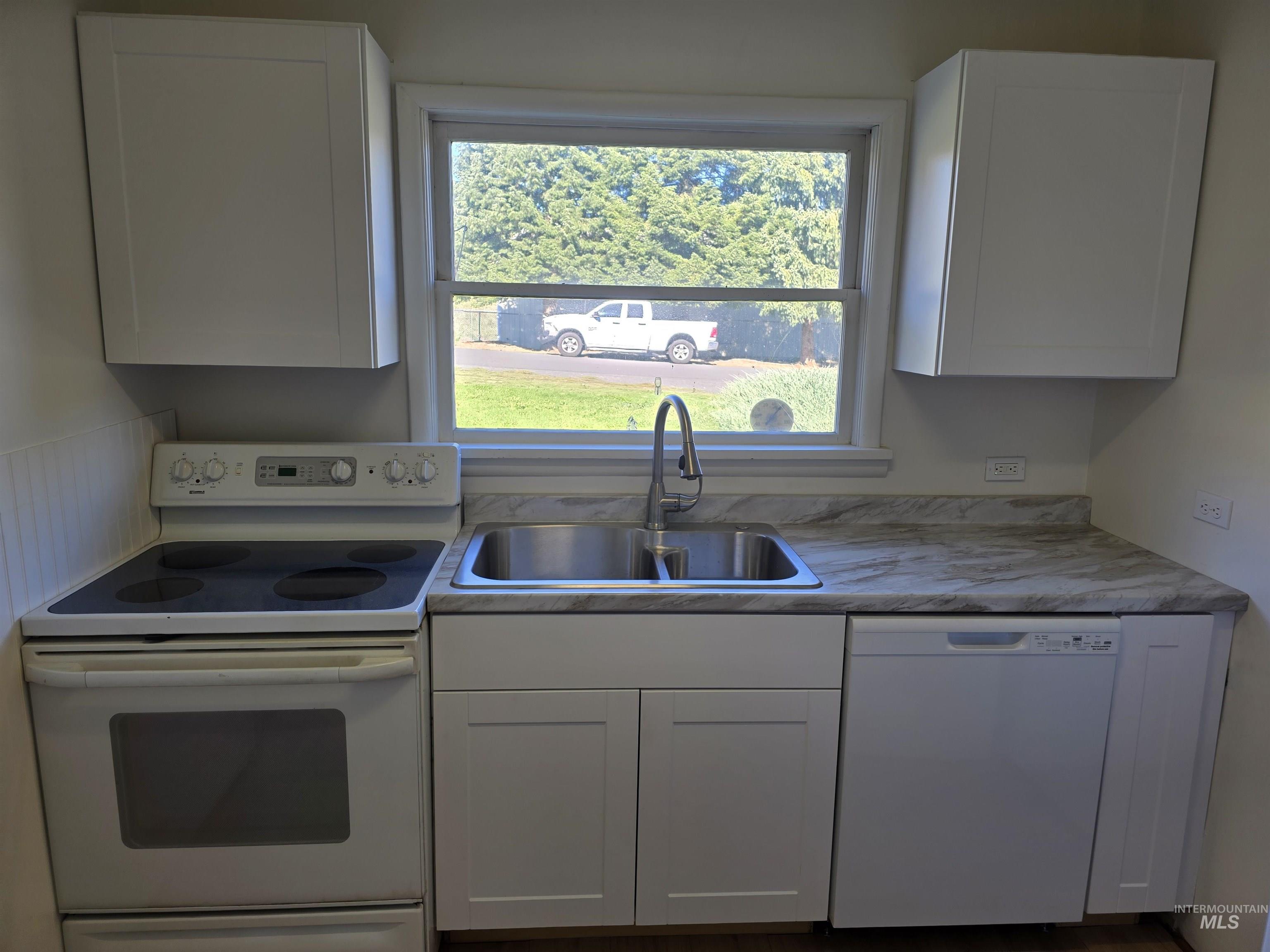 909 12th Street Kamiah, ID 83536 - Photo 11 of 36 Kitchen with white appliances, white cabinets, and light countertops