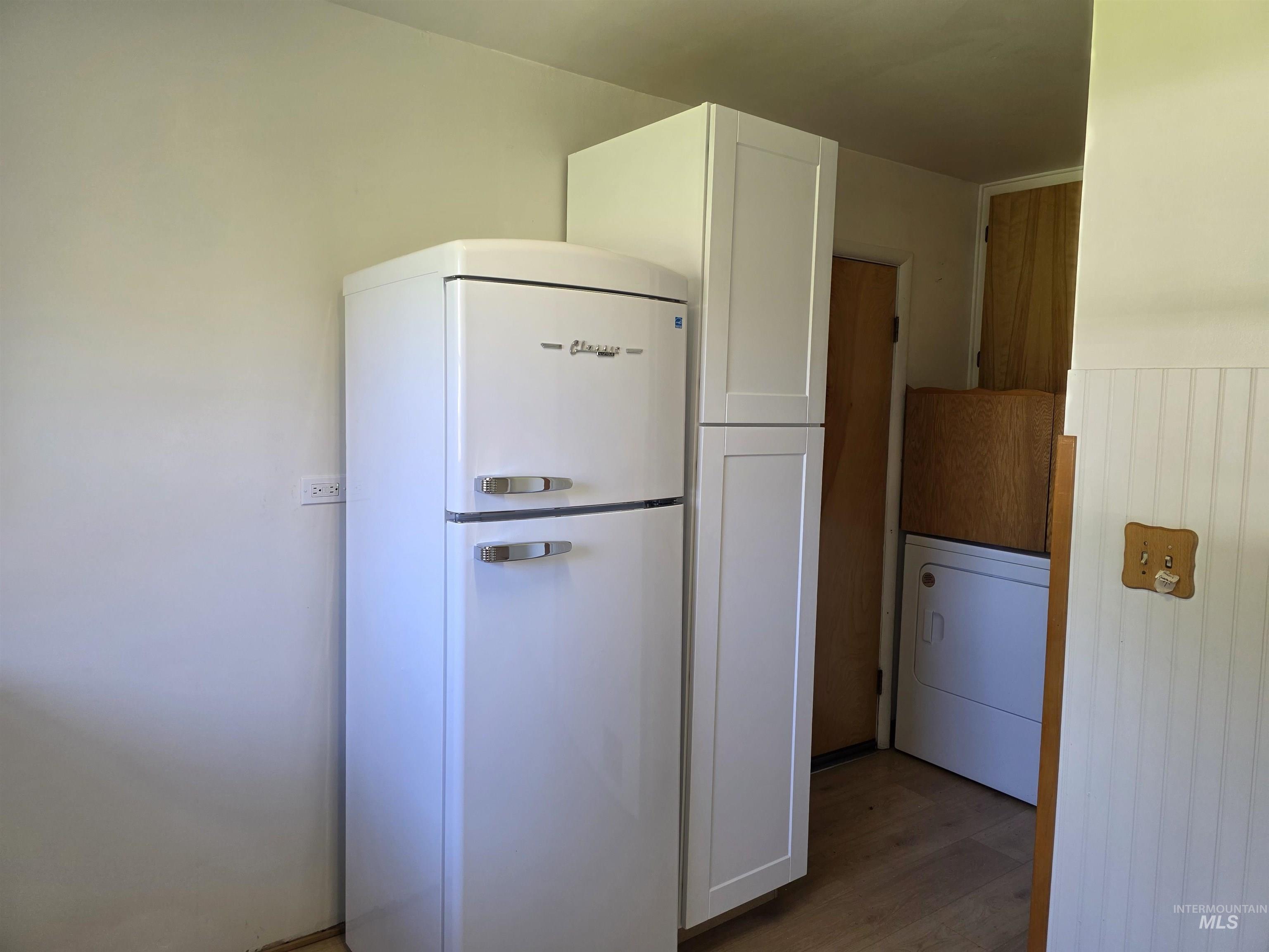 909 12th Street Kamiah, ID 83536 - Photo 12 of 36 Kitchen with freestanding refrigerator, white cabinets, washer / dryer, and light wood-style floors
