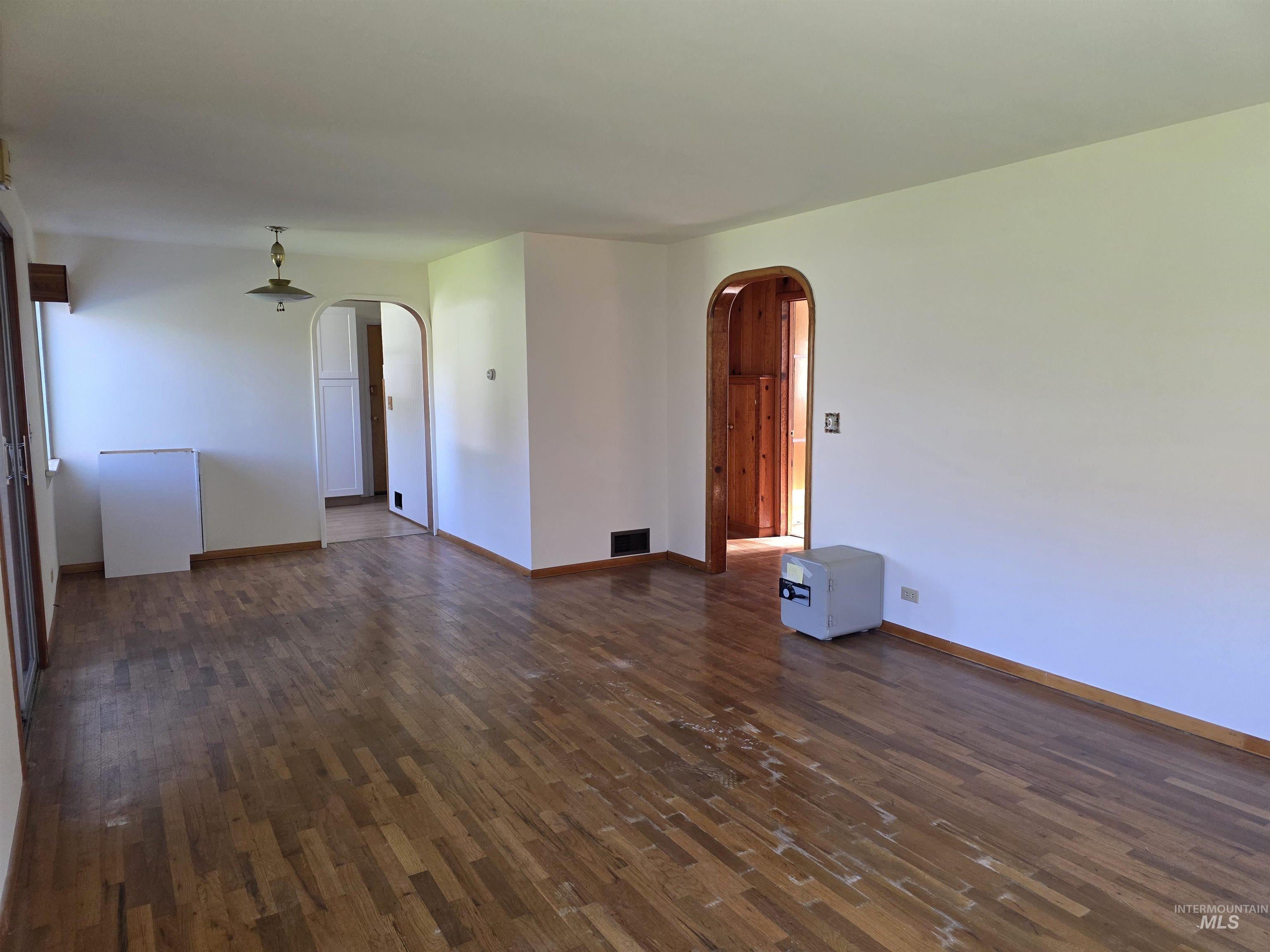 909 12th Street Kamiah, ID 83536 - Photo 9 of 36 Unfurnished room featuring dark wood-type flooring and arched walkways