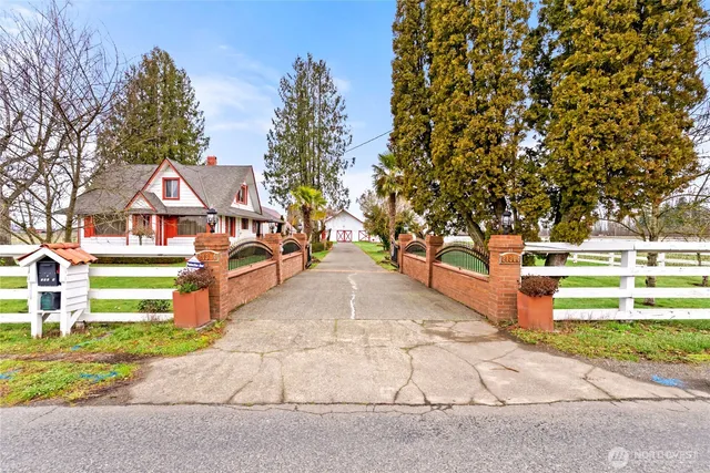 a view of residential houses with yard and road