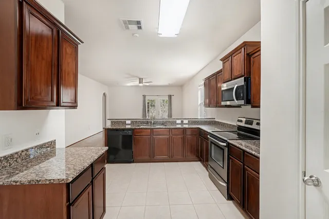 a kitchen with stainless steel appliances granite countertop a sink and stove top oven