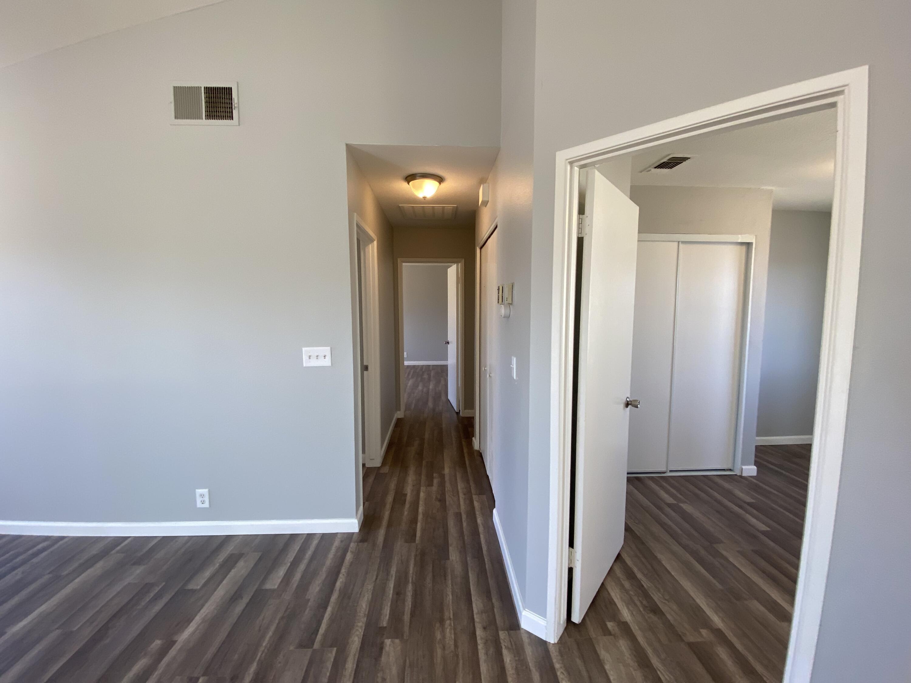 1241 South Ranger Street Ridgecrest, CA 93555 - Photo 12 of 26 a view of a hallway with wooden floor and a bathroom