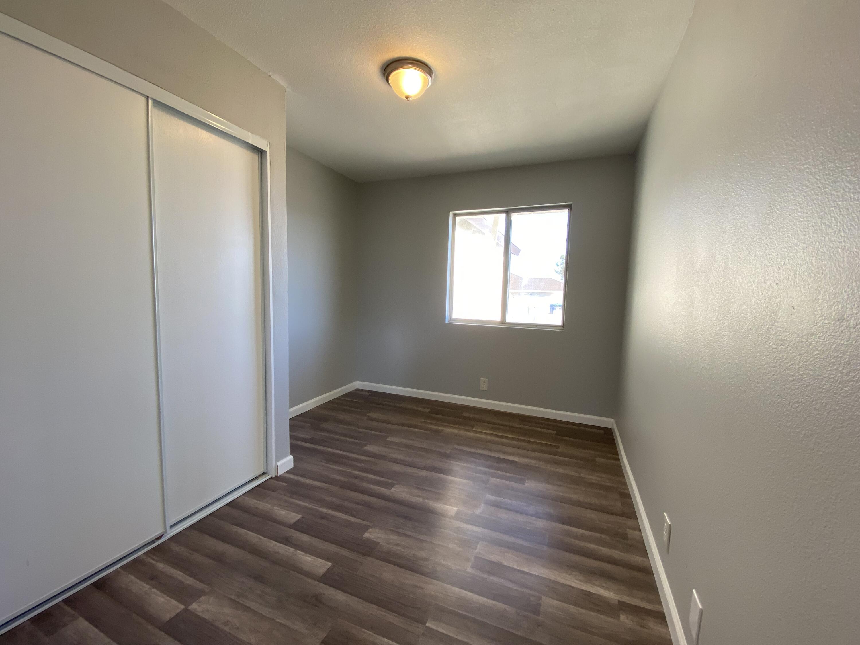 1241 South Ranger Street Ridgecrest, CA 93555 - Photo 10 of 26 an empty room with wooden floor and windows