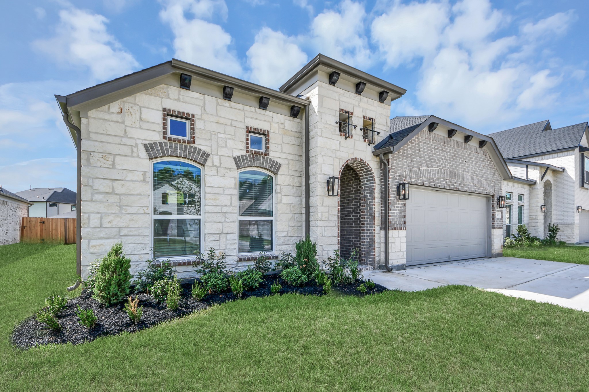 This home boasts lush green grass and meticulous landscaping. Its premium elevation showcases an exquisite blend of brick and stone features, complemented by modern coach lighting.