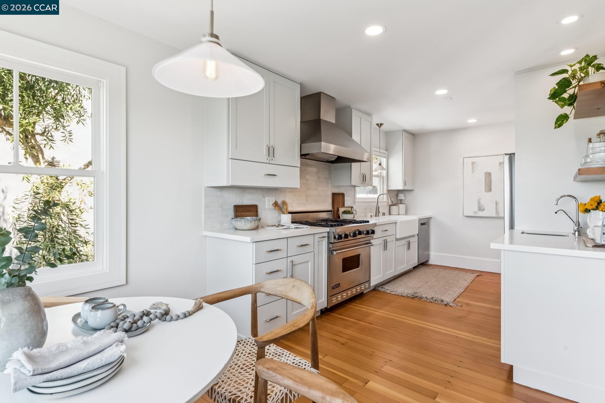 212 Yale Avenue Kensington, CA 94708 - Photo 25 of 70 a kitchen with stainless steel appliances a white stove top oven a sink a dining table and chairs