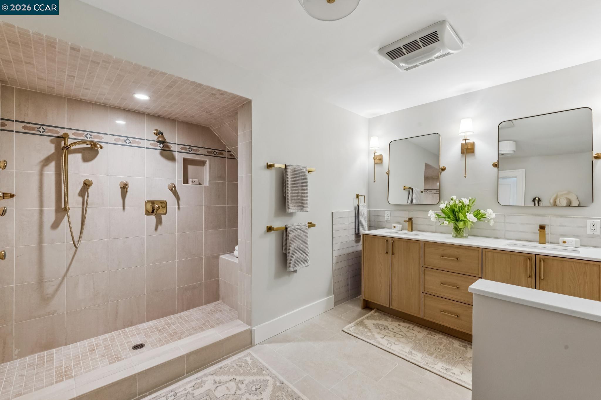 212 Yale Avenue Kensington, CA 94708 - Photo 41 of 70 a bathroom with a double vanity sink a large mirror a bathtub and shower