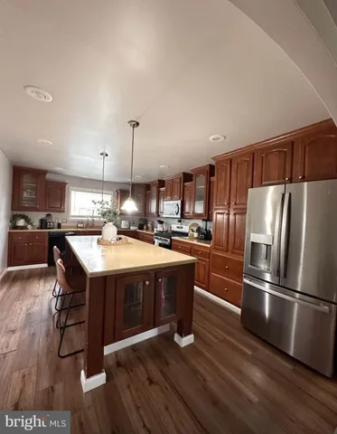 a kitchen with kitchen island granite countertop a sink cabinets and stainless steel appliances