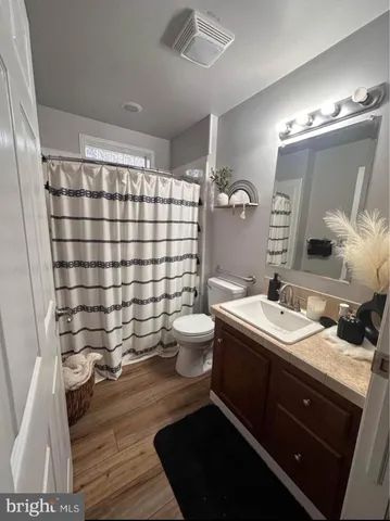 a bathroom with a sink a toilet a mirror and shower