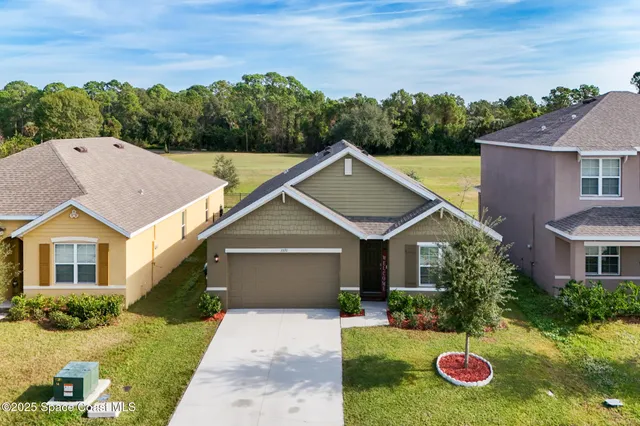 a front view of a house with a garden and plants