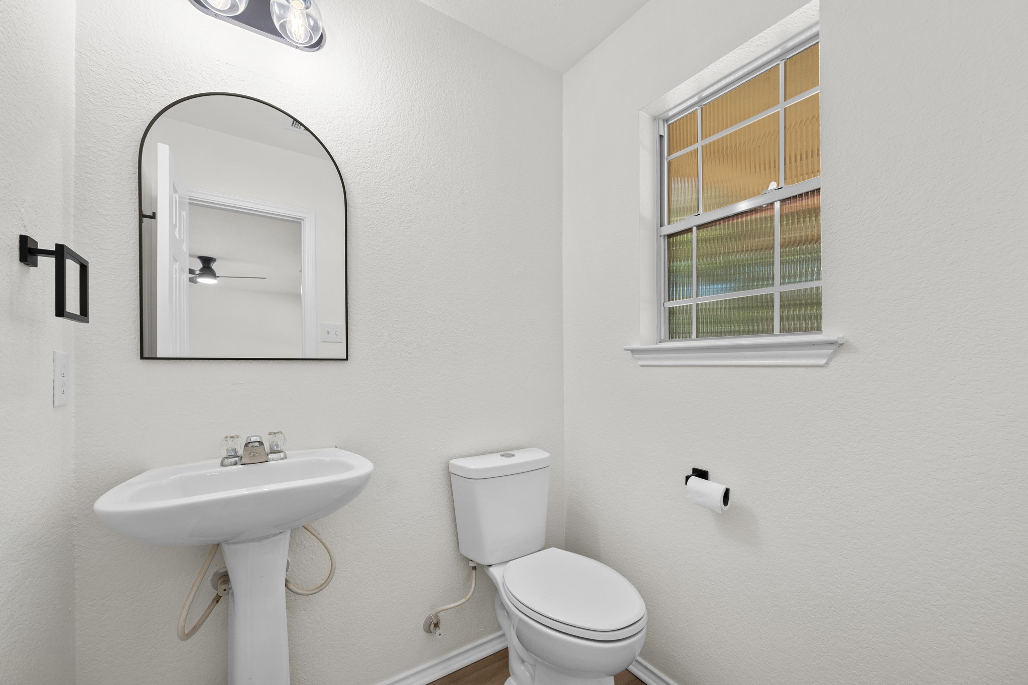 1818 Lost Maples Loop Cedar Park, TX 78613 - Photo 9 of 38 A well-lit powder room featuring a pedestal sink and window with textured glass.