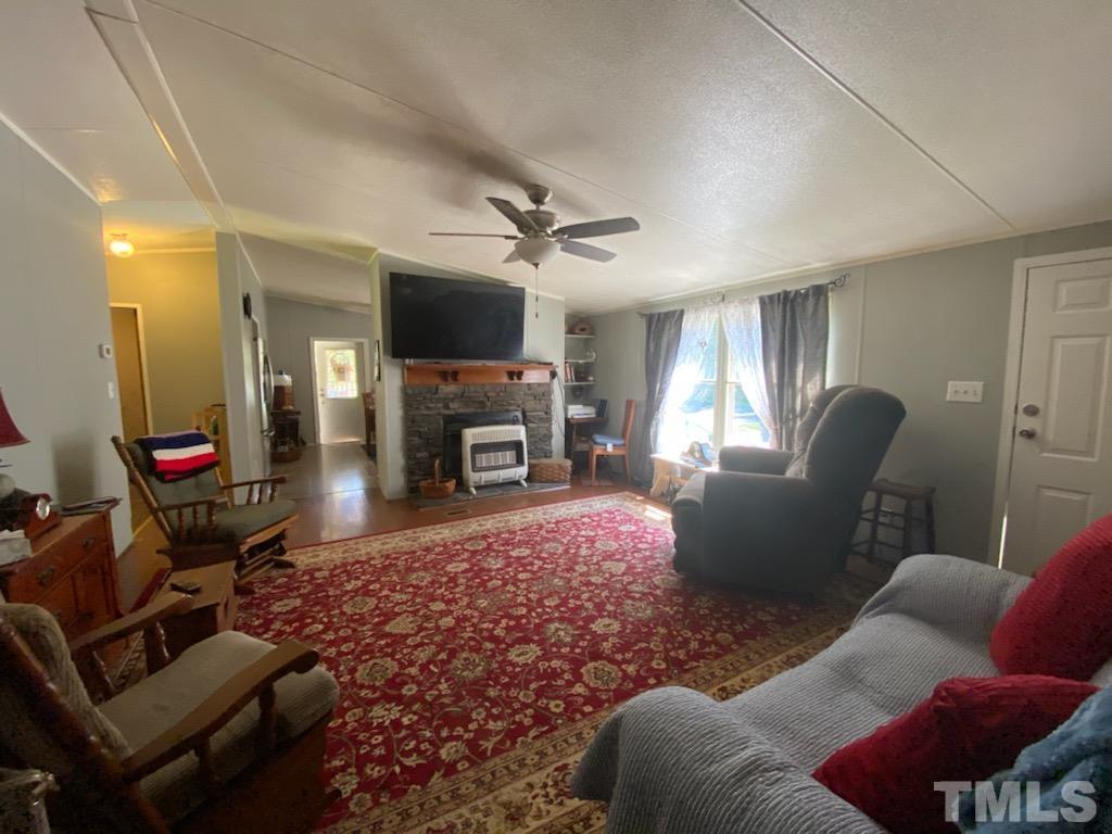 319 Cousin Road Rougemont, NC 27572 - Photo 5 of 17 a living room with furniture a flat screen tv and a fireplace