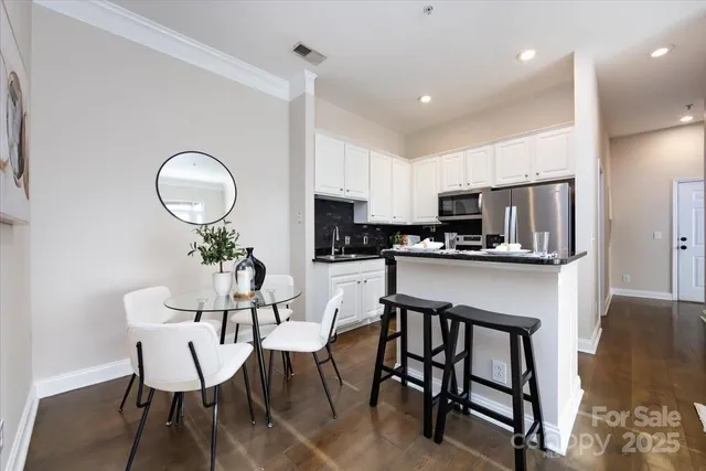 a kitchen with a table chairs refrigerator and cabinets
