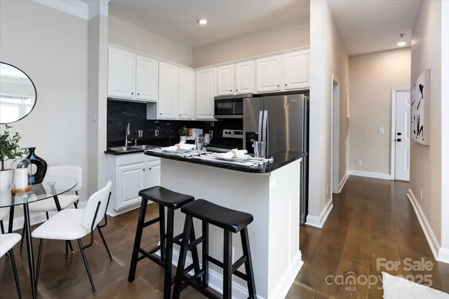 a kitchen with stainless steel appliances granite countertop a sink stove and cabinets