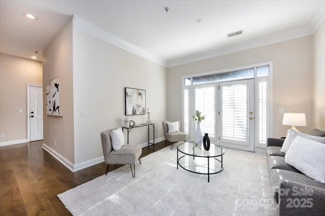 a living room with furniture a window and a wooden floor