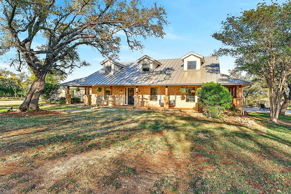 301 Medlin Creek Loop Dripping Springs, TX 78620 - Photo 28 of 40 View of front of house with covered porch, a front lawn, and a standing seam roof