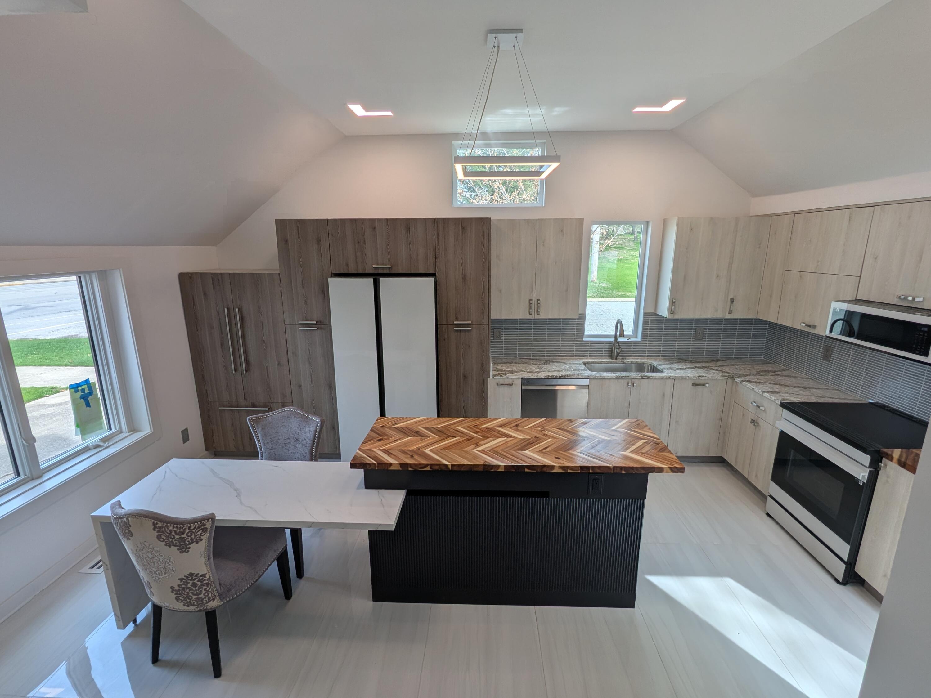 3298 Ridge Road Highland, IN 46322 - Photo 9 of 39 a kitchen with stainless steel appliances granite countertop a table chairs sink refrigerator and microwave