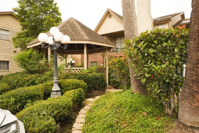 a front view of a house with a yard and fountain