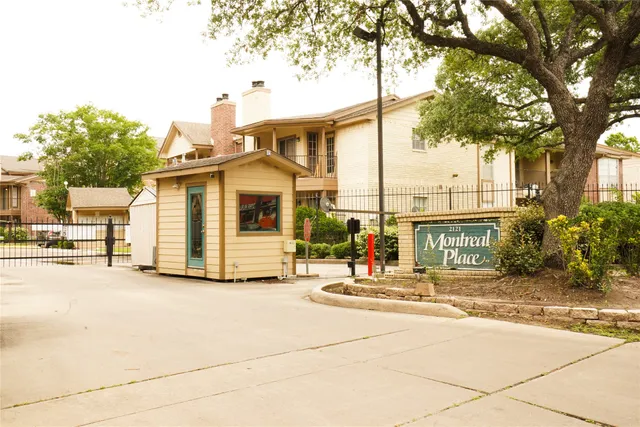 a view of a house with palm trees and a small yard