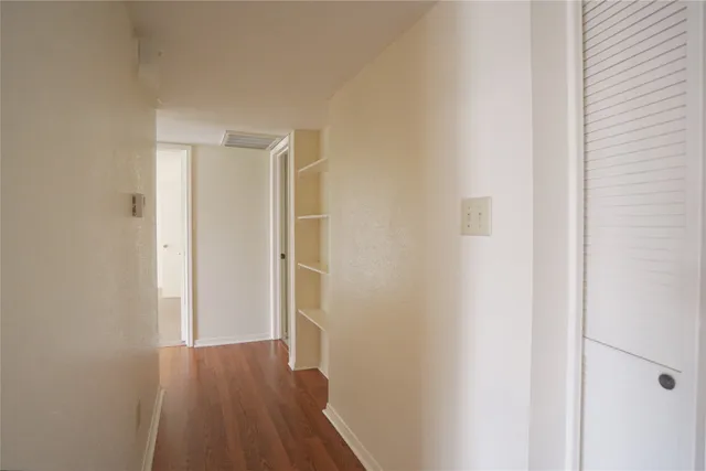 a view of a hallway with wooden floor