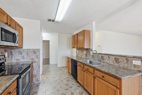 a kitchen with stainless steel appliances granite countertop a sink stove and cabinets