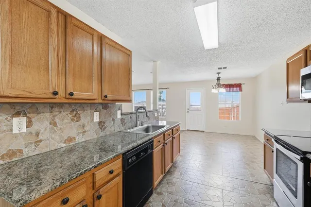 a kitchen with stainless steel appliances granite countertop a sink and a white cabinets