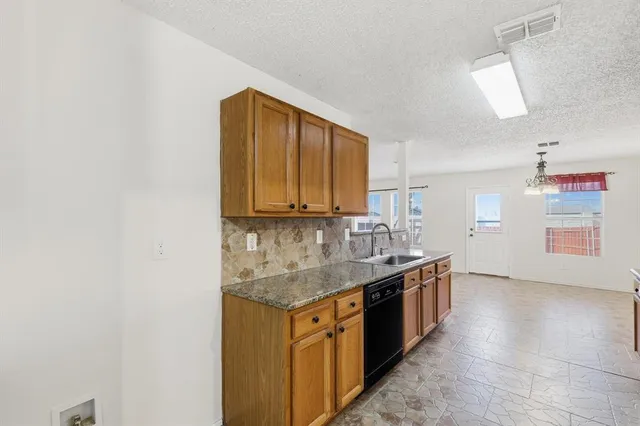 an empty room with chandelier fan and windows
