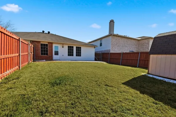 a view of a backyard with wooden fence