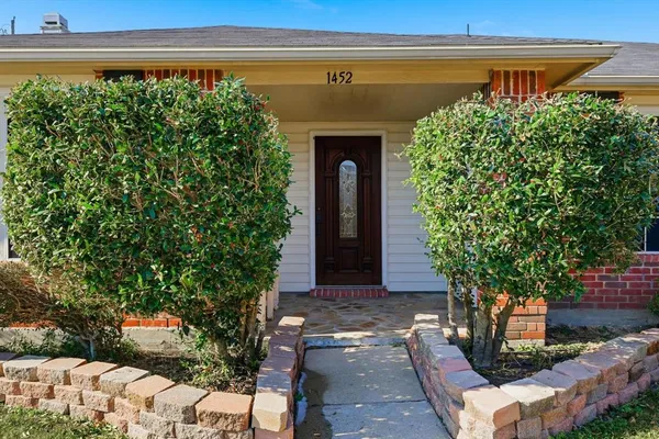 a front view of a house with plants