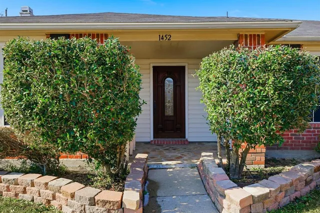 a front view of a house with plants