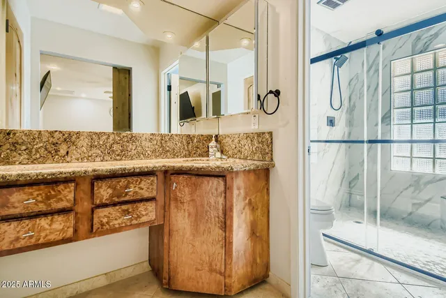 a bathroom with a granite countertop sink and a mirror