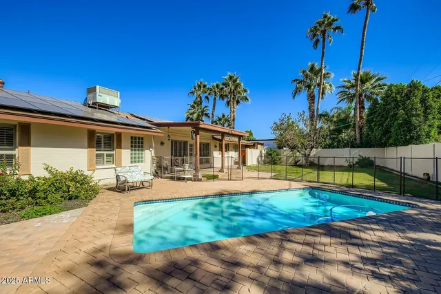 a view of a house with swimming pool and sitting area