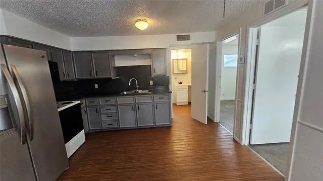 a kitchen with granite countertop white cabinets and black appliances